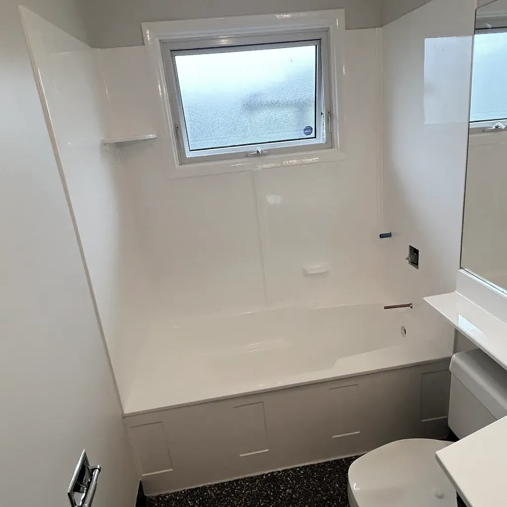 Freshly refinished cultured marble tub and surround in a bright bathroom